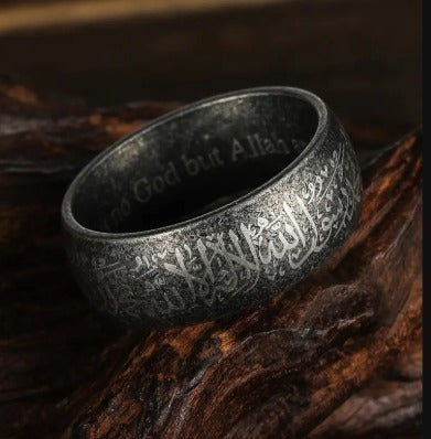 Close up of a vintage-style stainless steel ring featuring detailed Islamic-inspired engraving