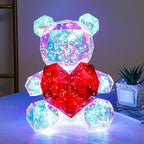 Transparent teddy bear shaped LED night light with a heart motif glowing with galaxy colours