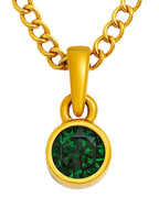 A close-up view of an emerald green birthstone pendant set in sterling silver with a gold-plated chain.
