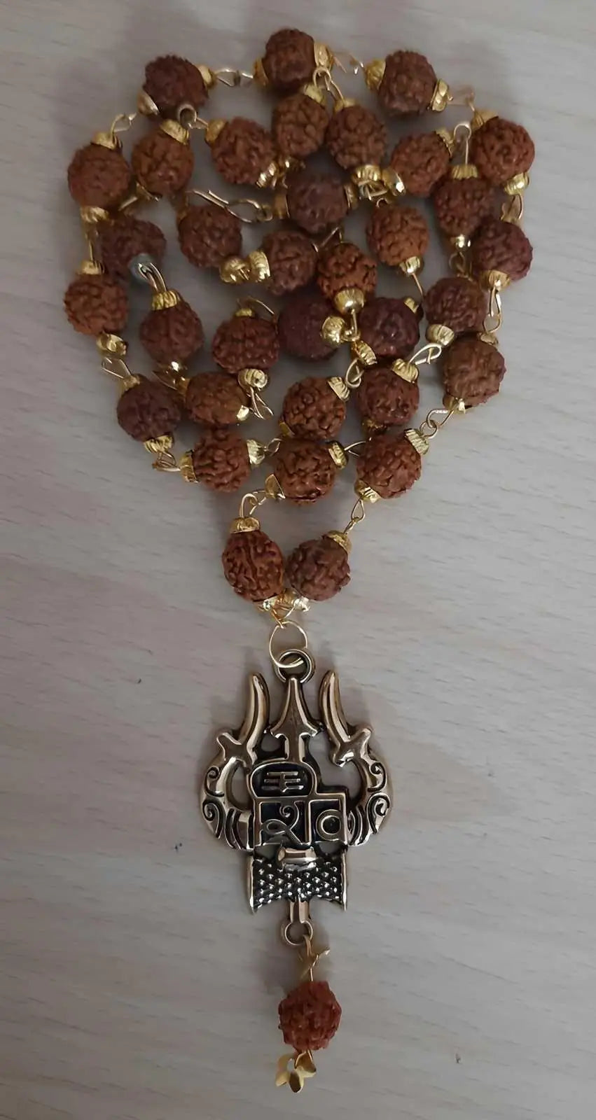 A close up view of a Rudraksha Gold Plated Chain showing the natural bead texture and metallic links