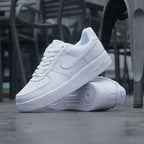 A pair of white men's perforated casual sneakers made of faux leather
