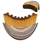 A plastic ergonomic lymphatic contour face brush with curved edges for facial massage