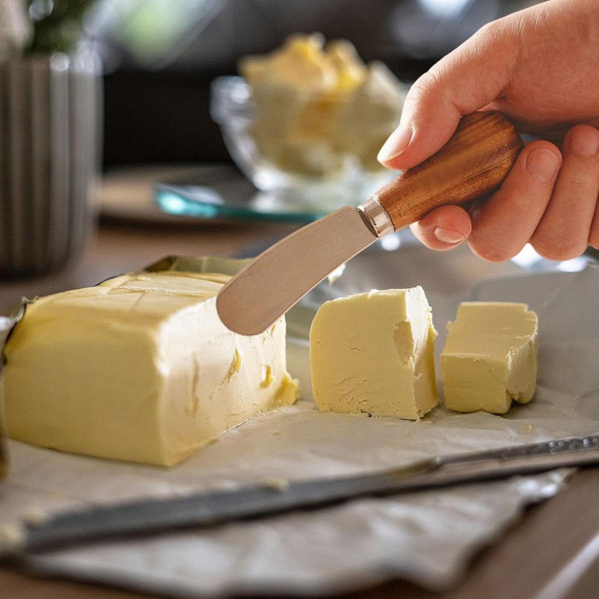 Mini butter knife featuring a stainless steel blade and a brown wooden handle
