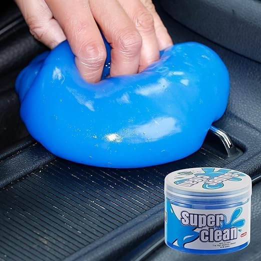 A soft cleaning gel putty being pressed into the vents of a car dashboard