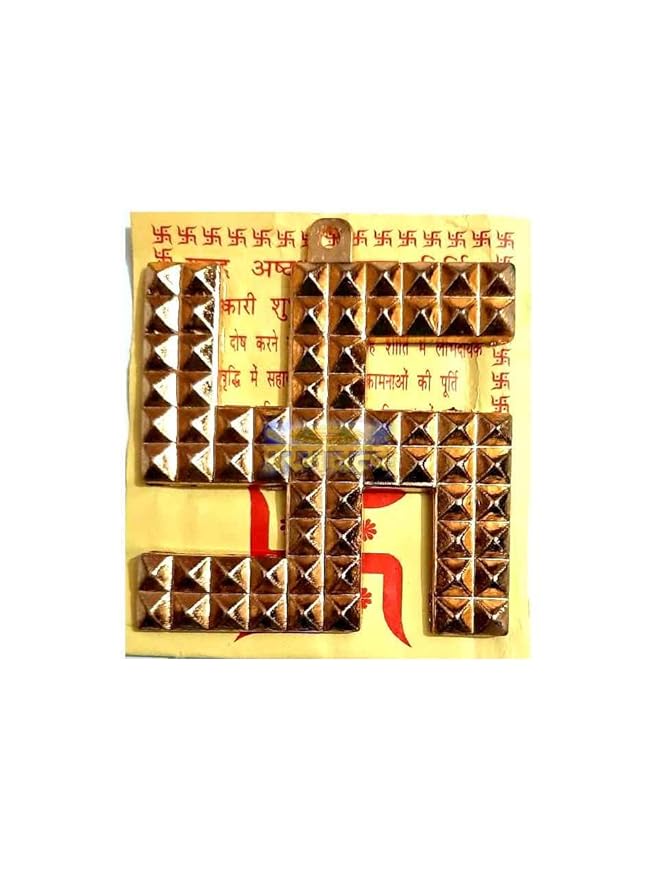 A close-up view of a polished brass Swastikam symbol sitting on a flat surface.